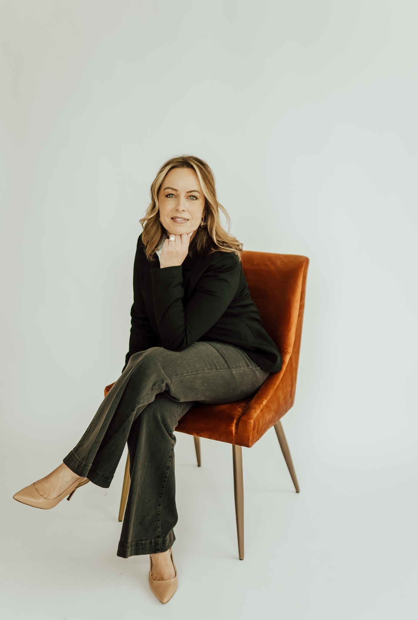Rachel Rowell, seated in a rust-colored chair