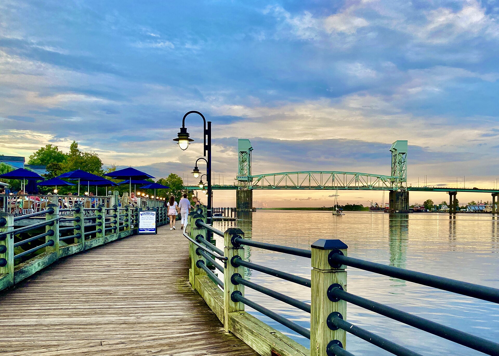 Wilmington's Riverwalk at sunset, with the Cape Fear Memorial Bridge in the background