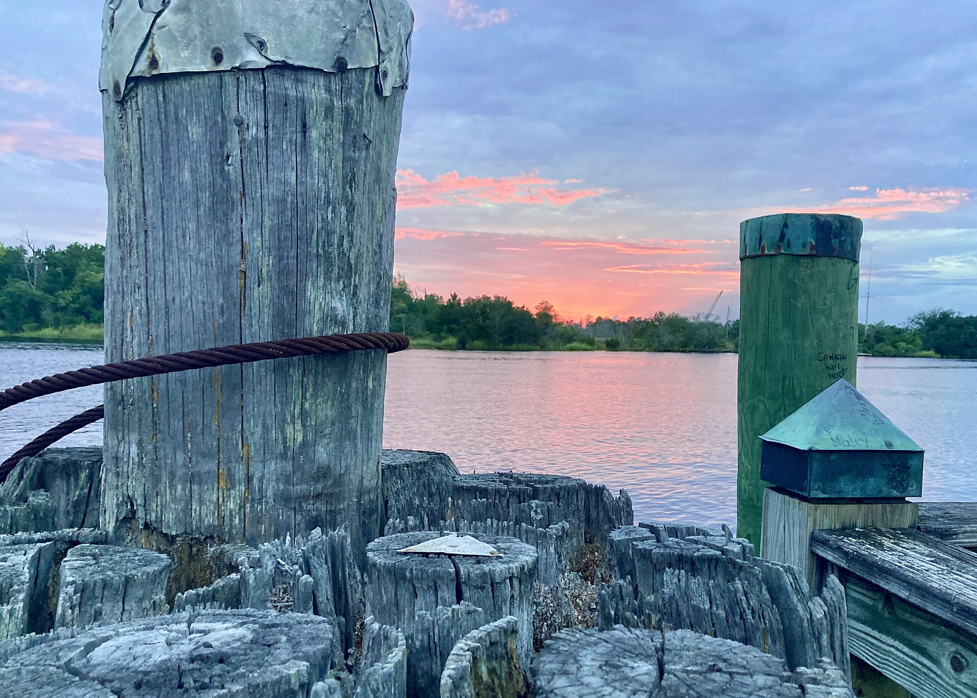 Weathered dock pilings on the Cape Fear River at sunset