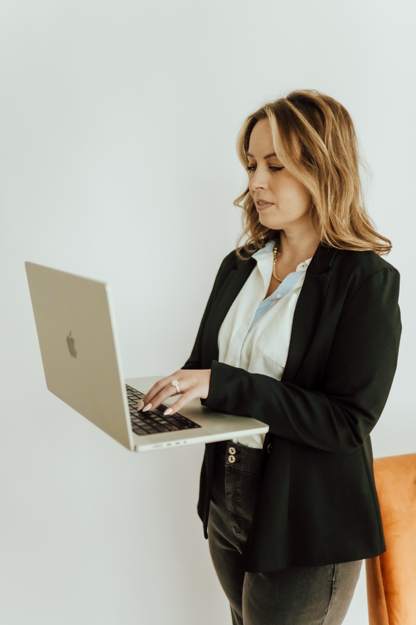 Rachel Rowell standing and working on a laptop