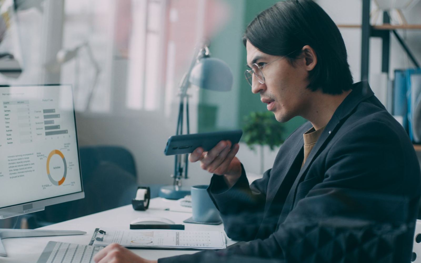 A professional reviewing data on screen while on a call