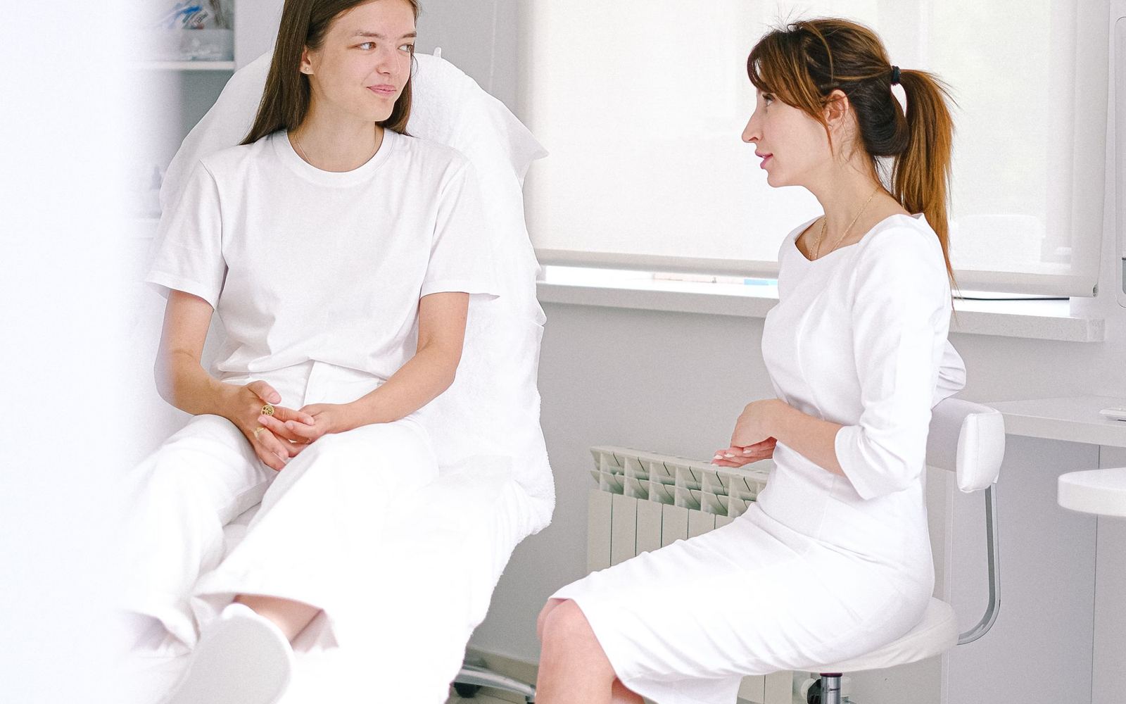 An aesthetic practitioner talking with a client before a consultation